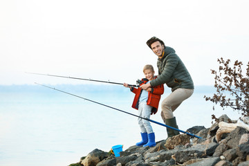 Canvas Print - Father with little son fishing on river