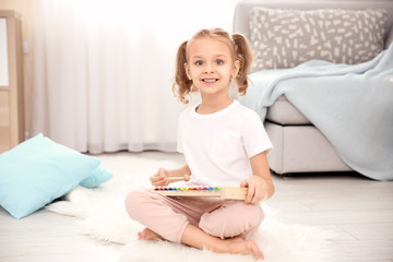 Canvas Print - Cute little girl playing with xylophone  at home