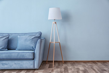 Canvas Print - Blue couch and floor lamp near color wall