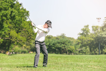 Wall Mural - Asian men playing golf. men play golf while standing on field