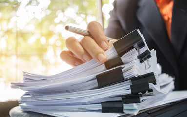 Canvas Print - Businessman hands working in Stacks of paper files for searching information on work desk office, business report papers,piles of unfinished documents achieves with clips indoor,Business concept