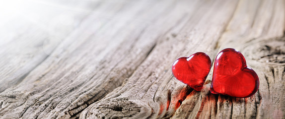 Wall Mural - valentines day background two red hearts on vintage wooden table