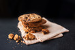 Heap of Chocolate chip cookies on dark background  with place for text. Choco cookie on  linen napkin on black slate board, selective focus with copyspace