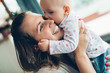 © NDABCREATIVITY - Happy cheerful family. Mother and baby kissing and hugging