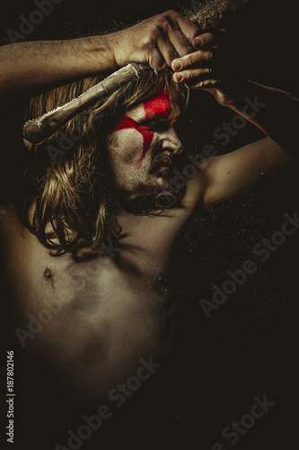 Plakat Wild warrior with metal sword and war paintings on the face, long hair