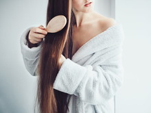 Cute, Young Woman In A Soft, Terry Dressing Gown, Combing Her Hair After Spa Services And Spa Treatments