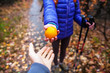 © zhukovvvlad - A woman with a backpack gives an orange.