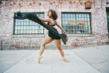 Mixed Race Woman Dancing Ballet On Sidewalk