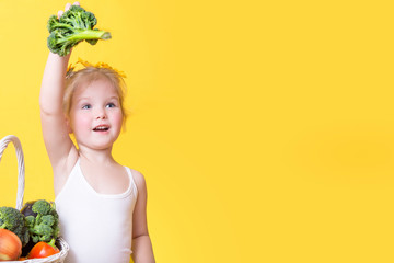 beautiful little happy girl with basket of vegetables and fruits