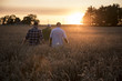 © John Fedele/Blend Images - Caucasian men walking though field of wheat