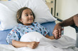 © FS Productions/Blend Images - Man holding hands with girl in hospital bed