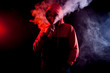© Виталий Сова - The man smoke an electric cigarette on the bright light background