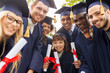 © Syda Productions - happy students in mortar boards with diplomas