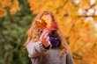 © Wavebreak Media - Woman showing red, yellow and brown maple leaves