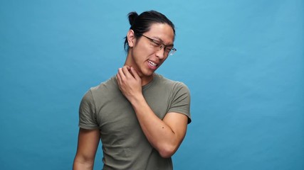 Poster - Confused asian man in t-shirt and eyeglasses having scabies over blue background