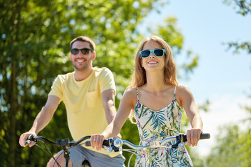 Poster - happy young couple riding bicycles in summer