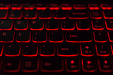 Red backlit computer keyboard macro shot of enter key
