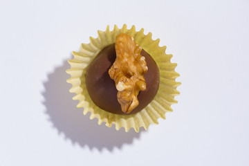 Homemade chocolate truffle. Known as Camafeu in Brazil. Flat lay of candy ball on white table.