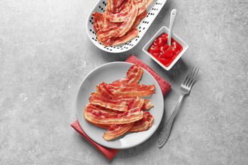 Wall Mural - Plates with cooked bacon rashers and sauce on table