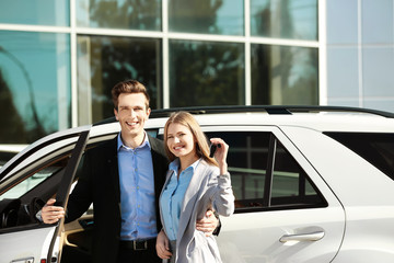 Sticker - Young couple with key near new car outdoors