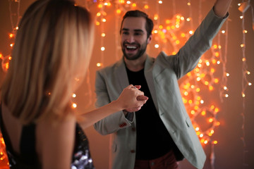 Wall Mural - Happy couple dancing together against blurred lights on engagement day