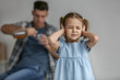 © Africa Studio - Little girl covering ears and her father drinking alcohol on background