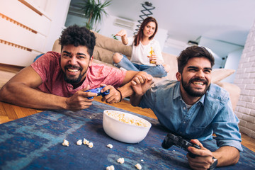 Wall Mural - Group of friends play video games together.