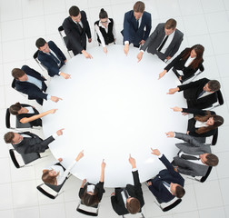 Poster - business team indicates the center of the round table.