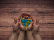 Woman's and child's hands holding a heart of blue and yellow color of world Down syndrome Day.