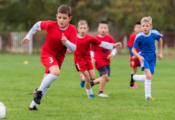 Wall Mural - Young children players football match on soccer field