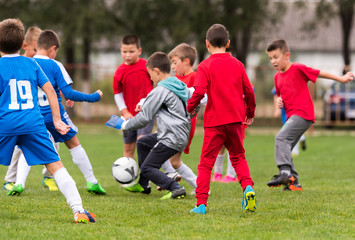 Wall Mural - Young children players football match on soccer field