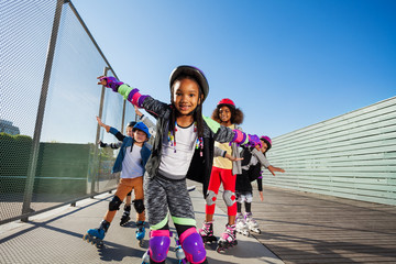 Wall Mural - African girl rollerblading with friends outdoors