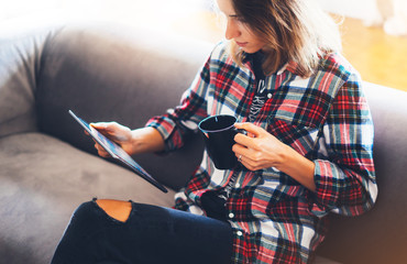 hipster girl using tablet technology and drink coffee in home, girl person holding computer on backg