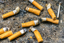 Many Cigarette Butts In The Dirty Ashtray. A Lot Of Cigarette Butts. Reason Of Lung Cancer. Lots Of Used Cigarette Butts As Litter.