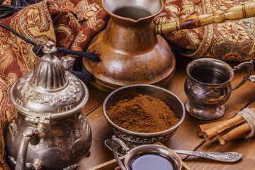 Wall Mural - Turkish coffee in silver dishes with ground coffee and coffee beans, cinnamon, anise. On a wooden background.