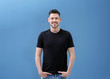 © Africa Studio - Young man in black t-shirt on color background. Mockup for design