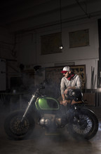 Man Posing With His Custom Motorbike In Garage