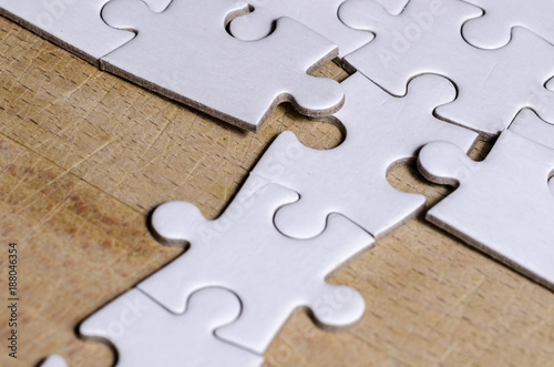 Fotografía the unexpected solution, white jigsaw/puzzle with a row in wrong position, over