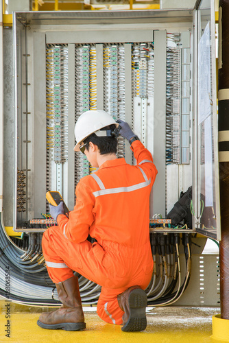 Cuadros en Lienzo Electrical and instrument technician using digital multi meter measuring electric voltage on programmable logic controller ( PLC ) junction box at offshore oil and gas processing platform