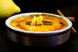 BURNT CREAM (CREME BRULEE) DECORATED WITH CINNAMON AND LEMON, READY TO EAT. DARK OLD BACKGROUND