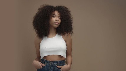 Wall Mural - mixed race black woman portrait with big afro hair, curly hair in beige background