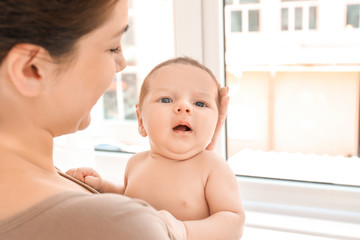 Wall Mural - Young mother with cute baby at home