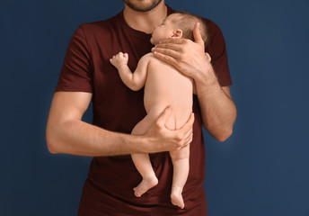 Wall Mural - Father with cute little baby on dark color background