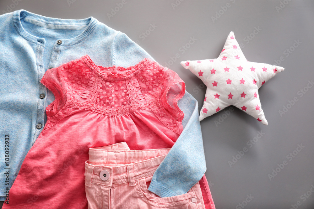 Composition with fashionable children clothes on grey background