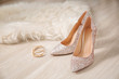 Pair of sparkly female shoes and elegant earrings on floor