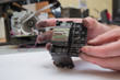 The repair specialist keeps a broken printhead from the inkjet printer in the hands stained. Repair of inkjet printers