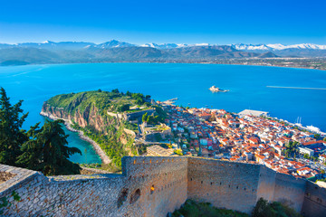 Wall Mural - Old town of Nafplion in Greece view from above with tiled roofs, small port and bourtzi castle on the Mediterranean sea water