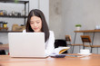 © NT_studio - Beautiful asian young woman working online on laptop sitting at coffee shop, professional female freelancer using notebook computer with connect to internet for distance job.