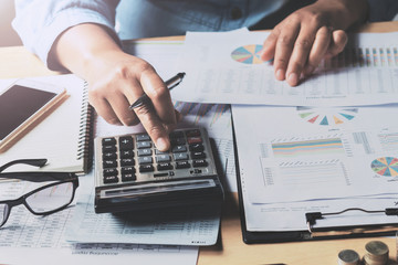 Poster - close up business woman using calculator to calculate data document of finance accounting in office