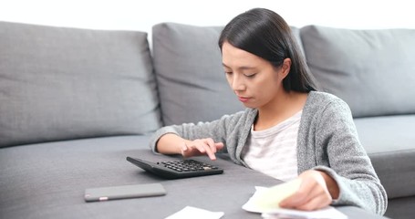 Wall Mural - Woman calculating the expense on calculator, and feeling shock after the result